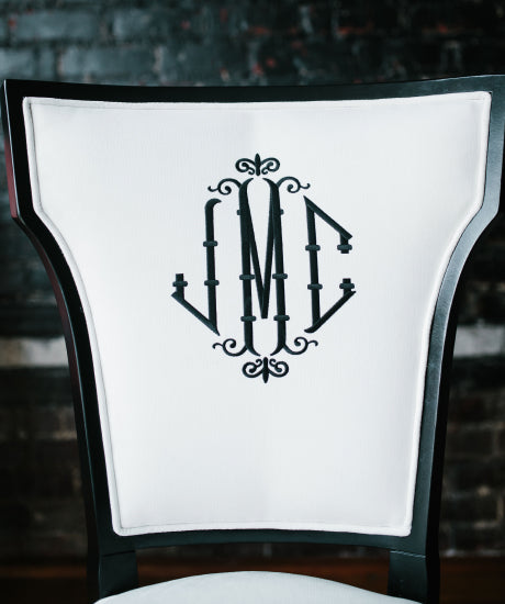 Monogrammed accent chair has white velvet fabric, a flared back, black wood finish and a black three-initial monogram. Ideal for use as a desk chair, dining chair or accent chair.